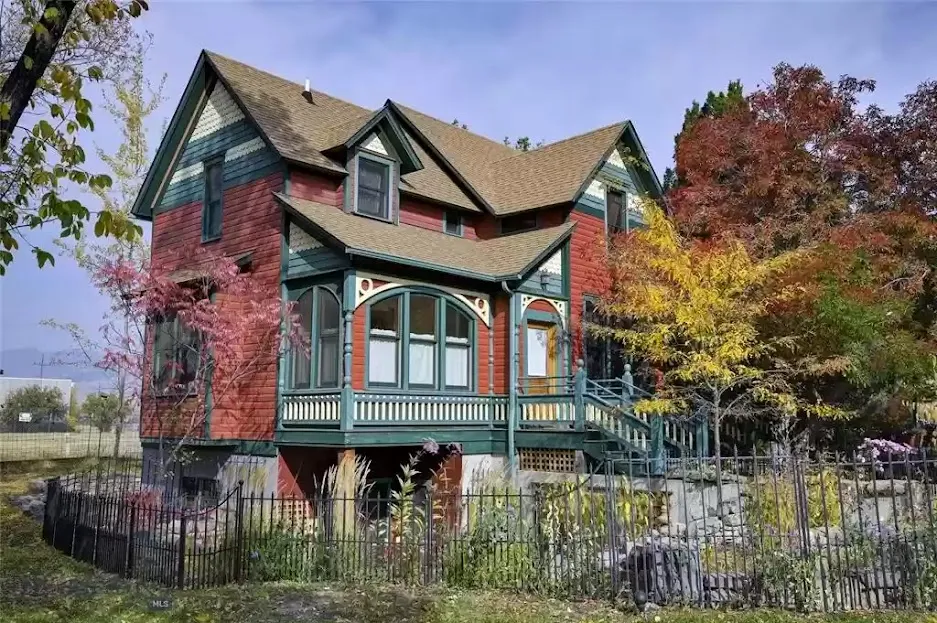 Lehrkind Garden House, a red Victorian with green trim behind an iron fence